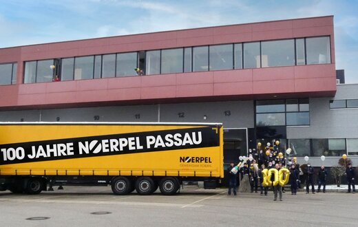 100 Jahre Noerpel Passau LKW Auflieger, Mitarbeiter vor Gebäude mit Luftballons